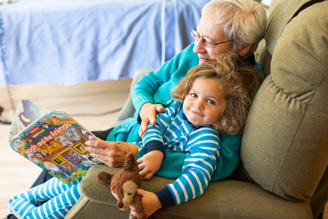 senior woman reading book to child